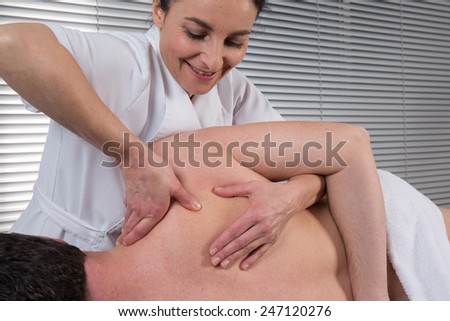 man is getting back massage from a physiotherapist