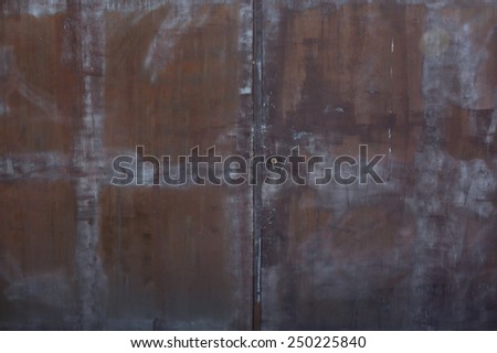 Closeup metal door with lock in grungy rusted style and good texture.