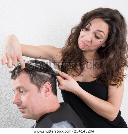 Young nice woman hairdresser makes hairstyle for a man
