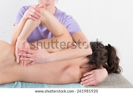 Woman therapist is doing massage on woman back in the spa salon