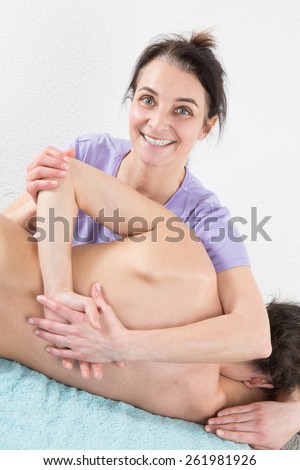 Woman therapist is doing massage on woman back