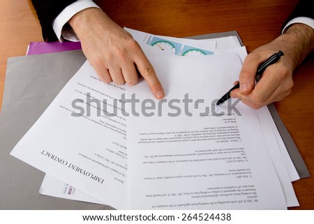 Close-up of female hand pointing at business document while explaining chart
