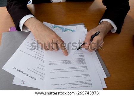 Close-up of female hand pointing at business document while explaining chart