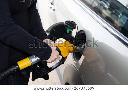 Hands of woman refueling her car at the gas station