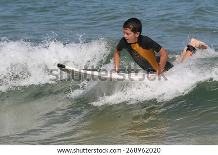 young teen boy learning how to surf
