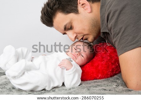 Loving father cuddling his new born baby