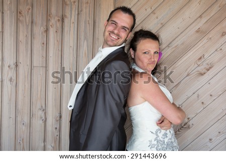 Wedding couple back to back under wooden background