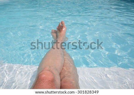 Man\'s feet on the background of a swimming pool.