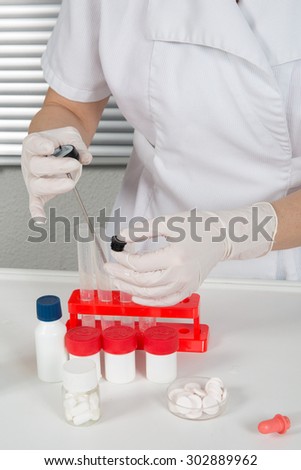 Laboratory assistant inserting laboratory glass bottle