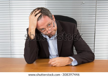 Too Much Work. Portrait of exhausted businessman sitting at office desk