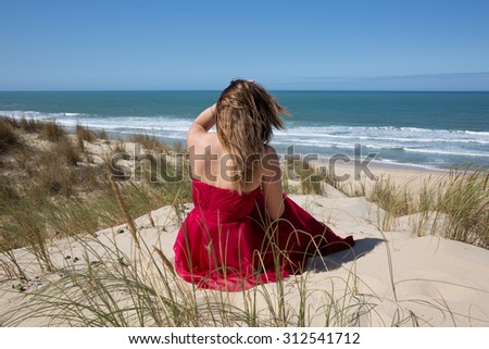 female with a red dress admiring a marine view
