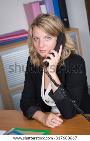Young businesswoman, phoning at the office, with a worried expression on her face.