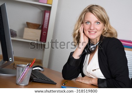 Blond pretty  secretary working with headphone.