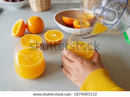 A young Asian woman preparing making fresh organic orange juice alone in the kitchen, homemade squeezing orange juice is best vitamin c source healthy life style concept  Foto stock © 