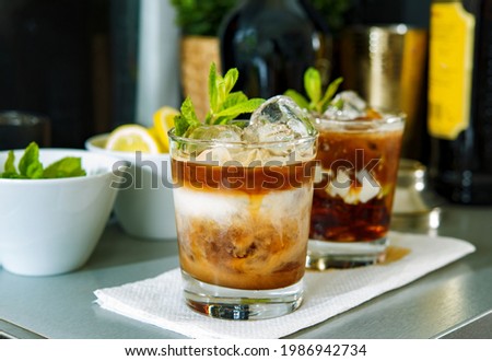 Foto Bild Zwei Mojito-Cocktails mit gealtertem Rum, Minze und verschiedenen Früchten. Einer mit Erdbeere und der andere mit Passionsfrucht