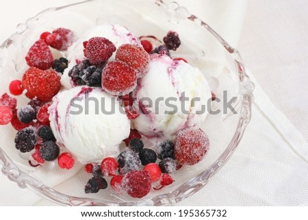 Home made yogurt ice cream with frozen berries on glass plate