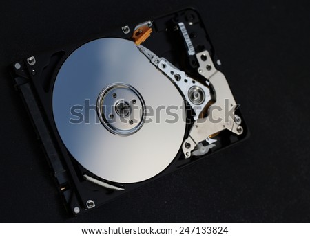 Hard disk drive, open, magnetic head and rotating platter visible
