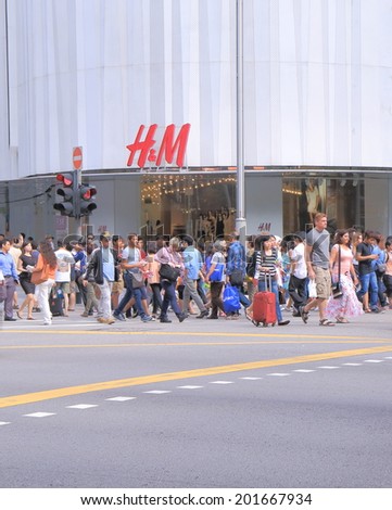 SINGAPORE - 26 May, 2014:Unidentified people walk across Orchard road. Orchard Road is a 2.2km long boulevard that is the retail and entertainment hub of Singapore.