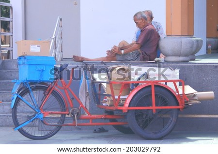 SINGAPORE - 28 May, 2014: Unidentified men rest from cardboard collection job in Chinatown. Chinatown is an ethnic neighbourhood featuring distinctly Chinese culture elements.