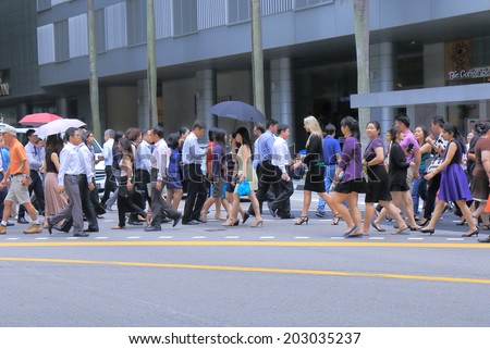 SINGAPORE - 27 May, 2014:Unidentified business people cross road in downtown Singapore. Singapore plays important role as an economic, financial and business centre of South East Asia.