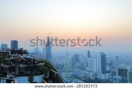 BANGKOK THAILAND - APRIL 20, 2015: Unidentified people watch Bangkok city view from rooftop bar. Bangkok is a capital city and business centre of Thailand.