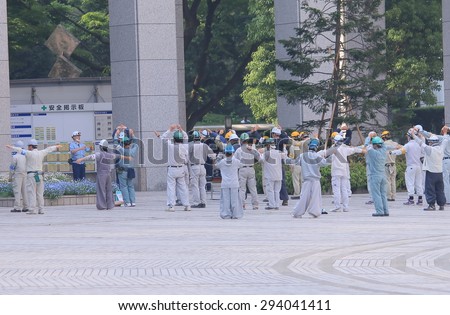 TOKYO JAPAN - MAY 8, 2015: Japanese construction workers do morning exercise in Shinjuku. It is common for fiscal workers to do group morning exercise in Japan.
