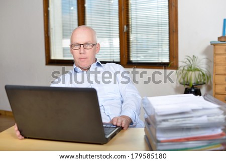 Senior business man in blue shirt at the office and computer