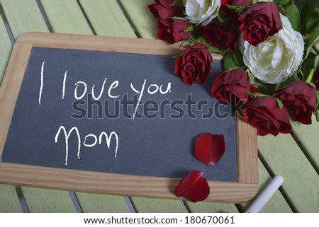 writing I love you mom on the blackboard and some roses