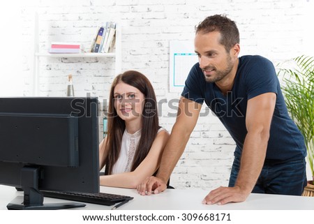 a young executive man and his secretary looking computer