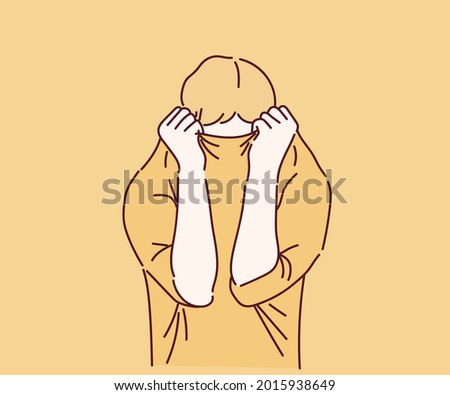 The boy was sad and embarrassed. put his head in the shirt. Hand drawn in thin line style, vector illustrations. 