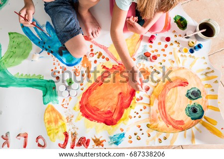 Kids painting together on a large piece of paper