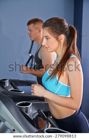 Man and woman  on treadmill in gym