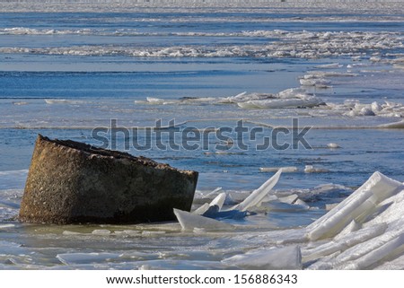 A concrete pipe in a frozen sea between ice floes