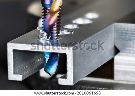 Closeup of tap and drill bit making a threaded hole in aluminum profile with metal shavings. Spiral twisted nano titanium coated product 2 in 1. Professional drilling and tapping tool. Chip machining. Photo stock © 