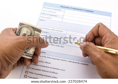 writing the insurance form with money in hand