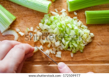 Woman hands carefully cut the celery for cooking