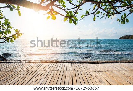Terrace view sea tree sunlight wooden table on the beach landscape nature with sunset or sunrise / wooden bridge balcony view seascape idyllic seashore silhouette tropical tree summer vacation beach 