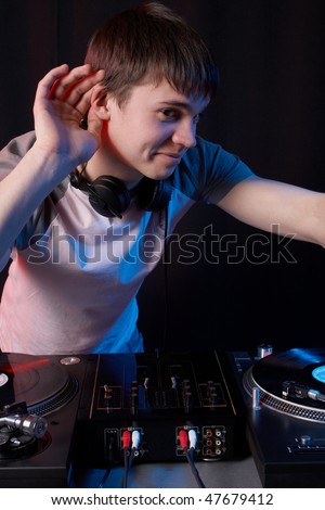 Young disk jockey for the vinyl disks and mixer in club