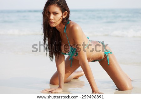 Asian fashion model in bikini on the sea coast