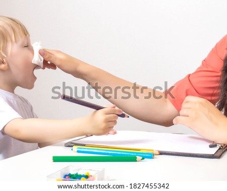 A little girl sneezes a runny nose and a cold, her mother wipes her nose with a napkin to her daughter. The concept of chronic and allergic rhinitis in children, copy space Zdjęcia stock © 