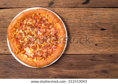 pizza pepperoni meat and sausage white plate on wooden table texture background