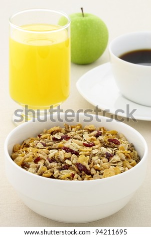delicious breakfast with orange juice, hot coffee, fresh apple and a healthy bowl of cereal.