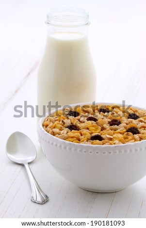 Delicious and nutritious breakfast muesli or granola cereal with milk on vintage styling.
