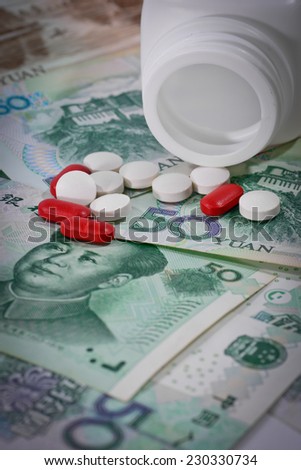 tablets on Yuan banknotes (renminbi),  for costs of medications and health insurance concept ;  with vignette filter.