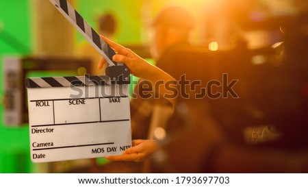 Close up Shot On Film Studio Set Young Camera Assistant Holds Empty Clapperboard. In the Background Director Shooting Green Screen Scene. History Costume Drama Movie.