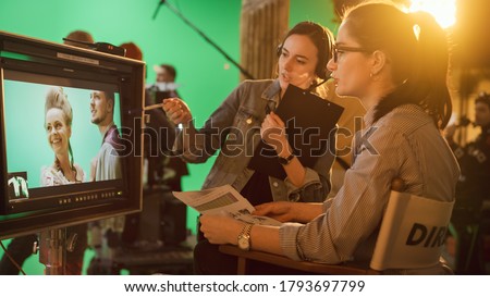 Famous Talented Female Director in Chair Looks at Display talks with Assistant, Shooting Blockbuster. Green Screen Scene in Historical Drama. Film Studio Set Professional Crew Doing High Budget Movie