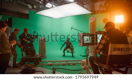 In the Big Film Studio Professional Crew Shooting Blockbuster Movie. Director Commands Cameraman to Start shooting Green Screen CGI Scene with Actor Wearing Motion Capture Suit and Head Rig