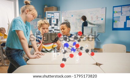 Three Diverse School Children in Chemistry Science Class Use Digital Tablet Computer with Augmented Reality Application, Looking at Educational 3D Animation of a Molecule. VFX, Special Effects Render