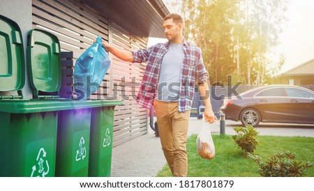 Caucasian Man is Throwing Away Two Plastic Bags of Trash next to His House. One Garbage Bag is Sorted with Biological Food Waste, Other with Recyclable Bottles Garbage Bin. Stockfoto © 