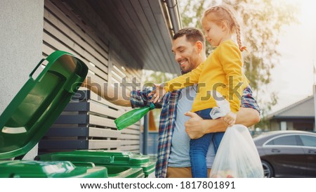 Father Holding a Young Girl and Throw Away an Empty Bottle and Food Waste into the Trash. They Use Correct Garbage Bins Because This Family is Sorting Waste and Helping the Environment. Stock foto © 